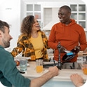 Three friends gather around a kitchen island, chatting and enjoying drinks, creating a lively and warm atmosphere.

