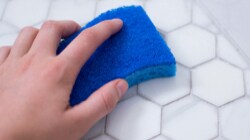 Person cleaning a floor with a Scotch-Brite™ Brand sponge
