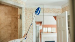 Person cleaning a glass shower with a Scotch-Brite™ Brand product  
