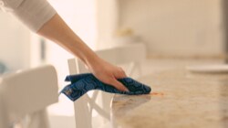 Person cleaning a counter with a Scotch-Brite™ Brand dishcloth 
