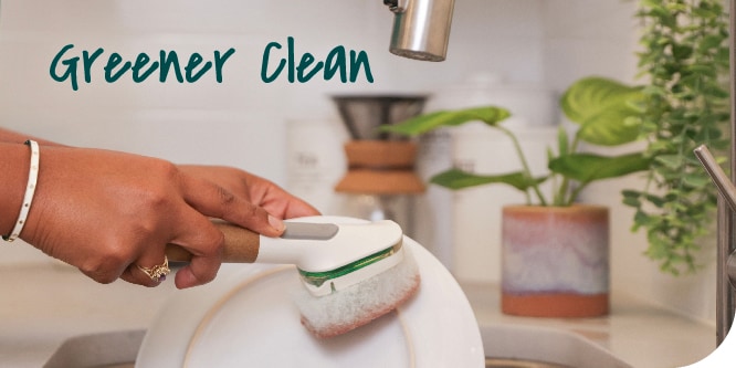 A person using the Scotch-Brite™ Greener Clean™ Non-Scratch Dishwand in their kitchen sink.
