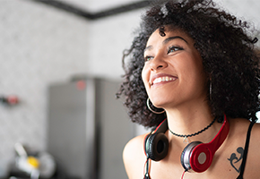 woman smiling with headphones around her neck