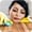 Person wearing yellow gloves cleaning a wooden surface with a sponge, focusing carefully.