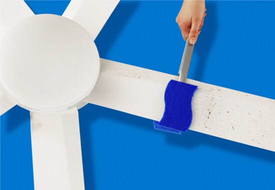A person sealing an envelope with a wet Scotch-Brite® Sponge.
