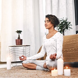woman meditating with candles